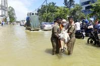 Firefighters help an elderly woman move to a safer area after heavy rainfall in Bangalore, India, Monday, Sept. 5, 2022. Life for many in the southern Indian city of Bengaluru was disrupted on Tuesday after two days of torrential rains set off long traffic snarls, widespread power cuts and heavy floods that swept into homes and submerged roads. (AP Photo/Kashif Masood)