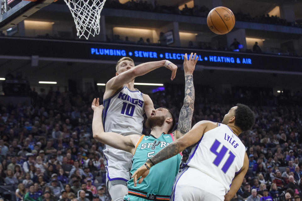 Sacramento Kings forward Domantas Sabonis (10) and forward Trey Lyles (41) guard San Antonio Spurs forward Sandro Mamukelashvili during the first quarter of an NBA basketball game in Sacramento, Calif., Sunday, April 2, 2023. (AP Photo/Randall Benton)