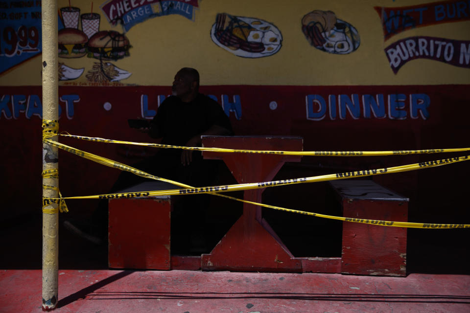 A man waits for his order in an outdoor dining area closed due to the coronavirus pandemic in the Vermont Square neighborhood of Los Angeles, Thursday, May 21, 2020. While most of California took another step forward to partly reopen in time for Memorial Day weekend, Los Angeles County didn't join the party because the number of coronavirus cases has grown at a pace that leaves it unable to meet even the new, relaxed state standards for allowing additional businesses and recreational activities. (AP Photo/Jae C. Hong)