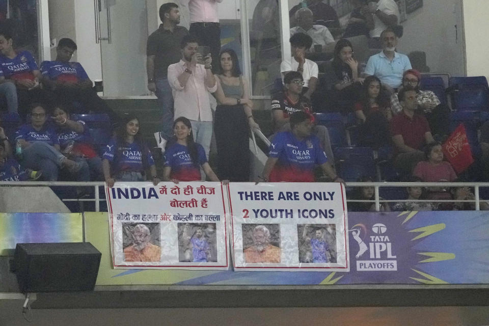 Banners featuring Indian Prime Minister Narendra Modi and Royal Challengers Bengaluru's Virat Kohli are displayed in the spectators area during the Indian Premier League eliminator cricket match between Royal Challengers Bengaluru and Rajasthan Royals in Ahmedabad, India, Wednesday, May 22, 2024. (AP Photo/Ajit Solanki)