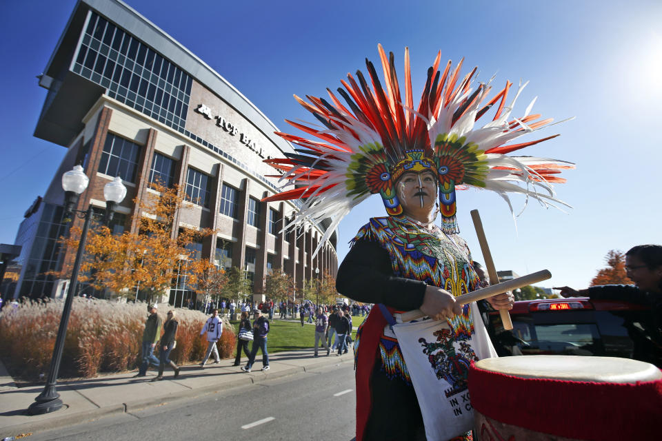 FILE - A woman plays a drum during a "No Honor in Racism Rally" in front of TCF Bank Stadium before an NFL football game between the Minnesota Vikings and the Kansas City Chiefs, on Oct. 18, 2015, in Minneapolis. The group objects to the Kansas City Chiefs name, and other teams' use of Native Americans as mascots. As the Kansas City Chiefs return to Super Bowl on Sunday, Feb. 12, 2023, for the first time in two years, the movement to change their name and logo will be there again. (AP Photo/Alex Brandon, File)