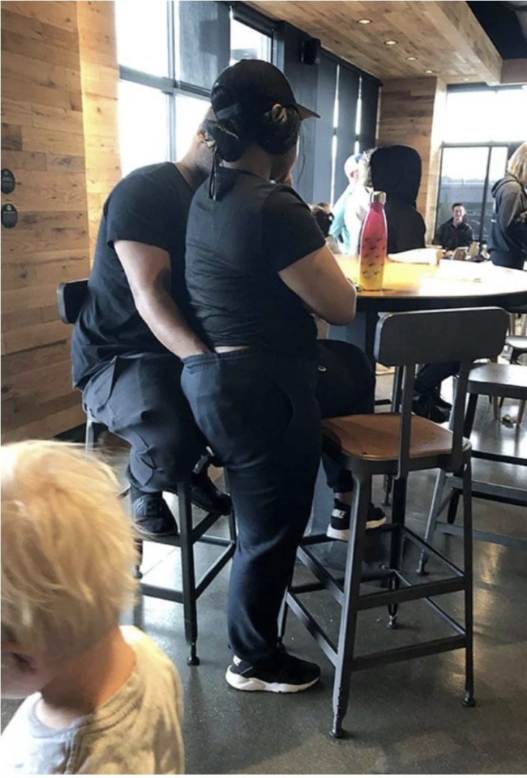 man with his hands in his girlfriend's pants in a restaurant