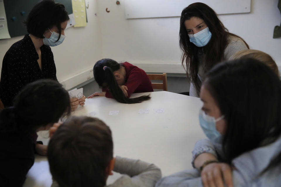 Therapists talk to children in the pediatric unit of the Robert Debre hospital, in Paris, France, Tuesday, March 2, 2021. France's busiest pediatric hospital has seen a doubling in the number of children and young teenagers requiring treatment after attempted suicides. Doctors elsewhere report similar surges, with children — some as young as 8 — deliberately running into traffic, overdosing on pills and otherwise self-harming. (AP Photo/Christophe Ena)