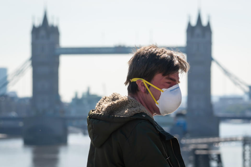 A man wearing a protective face mask crosses London Bridge, in London, during morning rush hour after the introduction of measures to bring the country out of lockdown. (Photo by Dominic Lipinski/PA Images via Getty Images)