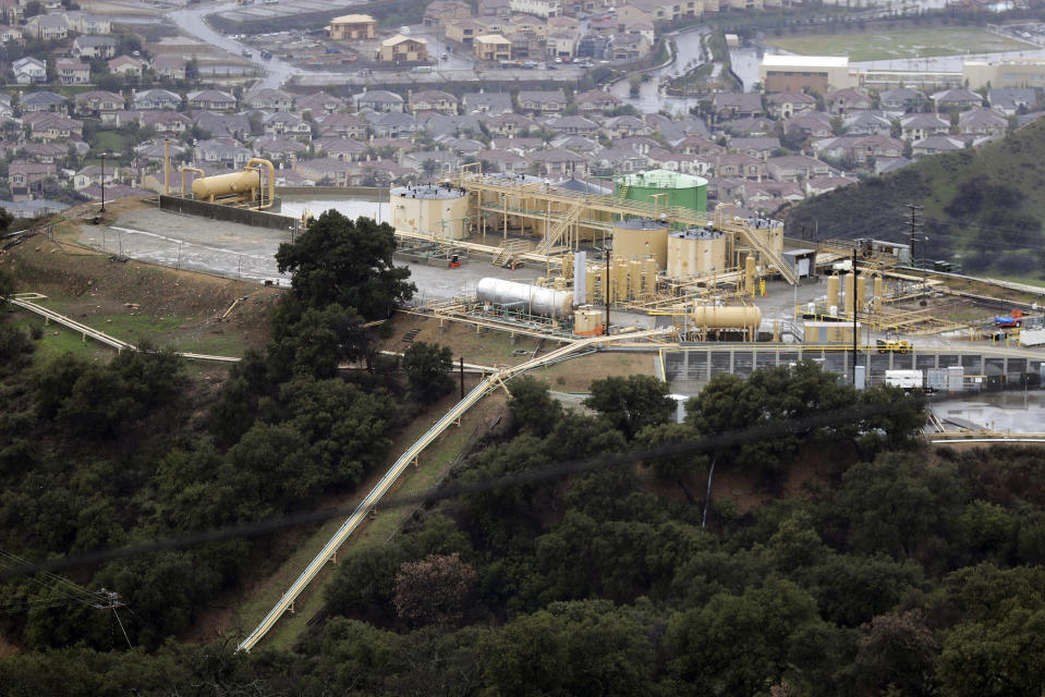 FILE - This Jan. 12, 2017, file photo shows gas gathering plant on a hilltop at the Southern California Gas Company's Aliso Canyon storage facility near the Porter Ranch neighborhood of Los Angeles. Attorneys for families sickened and forced from their Los Angeles homes after the nation's largest-known natural gas leak have reached a $1.8 billion settlement with the utility. The settlement announced Monday, Sept. 27, 2021, with Southern California Gas Co. and its parent company will compensate 35,000 plaintiffs from the 2015 blowout that took nearly four months to contain. (AP Photo/Jae C. Hong, File)