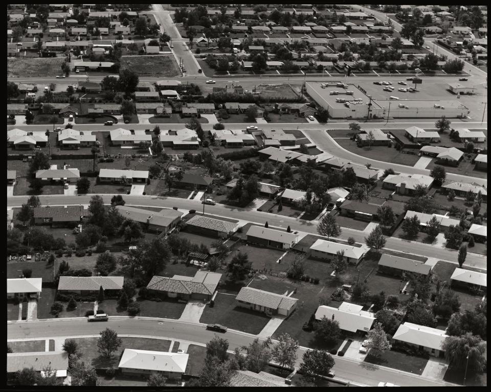 Tract homes in suburban development, homes, lawns, driveways and roads comprise a typical suburban neighborhood, circa 1967