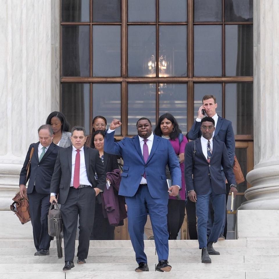 Andrew Brennen, far right, walks down the steps of the U.S. Supreme Court with Damon Hewitt, center, chief executive of the Lawyer’s Committee for Civil Rights Under Law.
