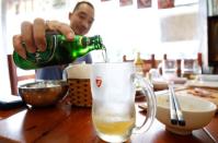 A man pours Saigon beer (Sabeco) into a mug at a restaurant in the Old Quarters in Hanoi