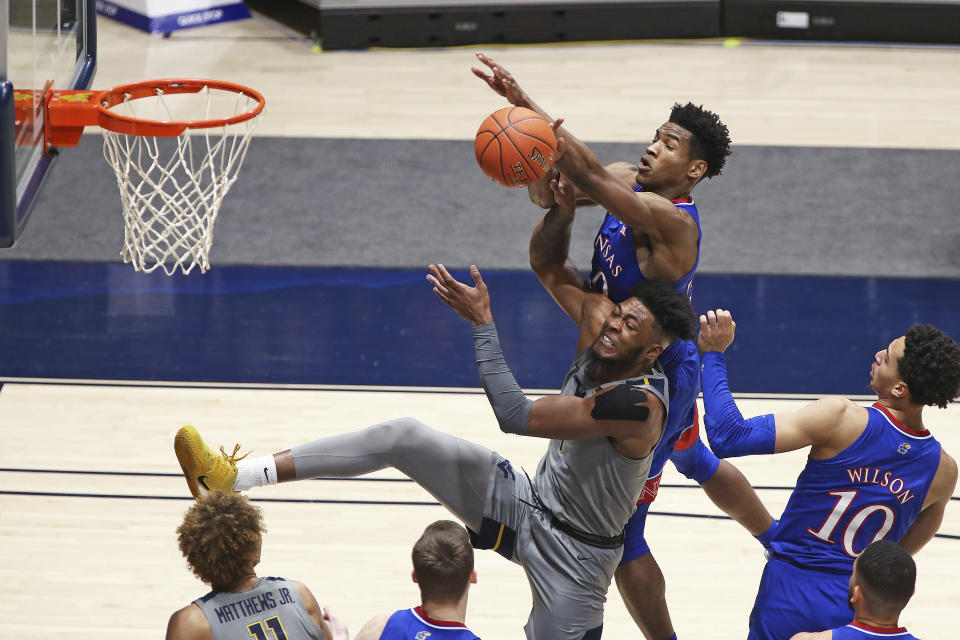 West Virginia forward Derek Culver (1) and Kansas guard Ochai Agbaji (30) go for a rebound during the first half of an NCAA college basketball game Saturday, Feb. 6, 2021, in Morgantown, W.Va. (AP Photo/Kathleen Batten)