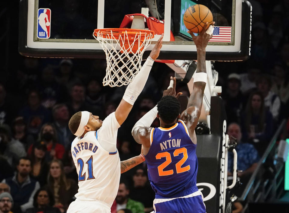 Washington Wizards' Daniel Gafford (21) tries to defend Phoenix Suns' Deandre Ayton (22) during the first half of an NBA basketball game in Phoenix, Tuesday, Dec. 20, 2022. (AP Photo/Darryl Webb)