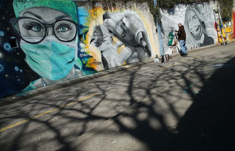 Artist Perez paints a graffiti of a cashier to pay tribute to essential workers in Gland