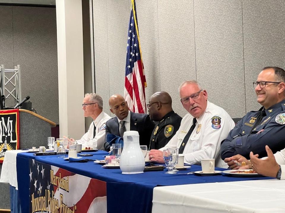 Maryland Gov. Wes Moore, second from left, listens to Berlin Police Chief Arnold Downing, third from left, during the Maryland Municipal League's Police Executive Association breakfast in Ocean City on June 27, 2023. Downing, the state's longest serving chief, is the immediate past chair of the association and Moore presented the award of the state's 