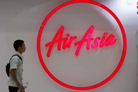 A man walks past the logo of AirAsia at Don Muang International Airport in Bangkok, Thailand, June 14, 2016. REUTERS/Chaiwat Subprasom