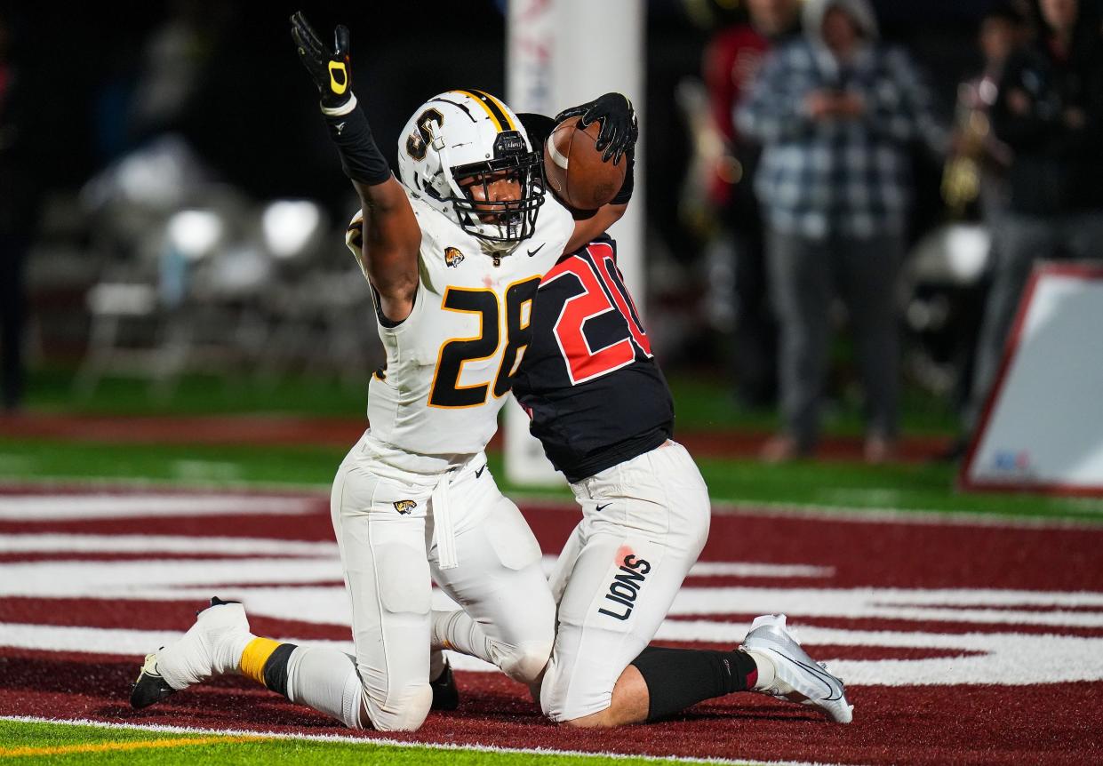 Saguaro linebacker Joseph Clark (28), at left, looks to the referee for a call after making a catch while guarded by Liberty defensive back Wesley Grim (20), at right, during the Open Division semifinal between Liberty and Saguaro at Mountain Ridge High School on Saturday, Dec. 3, 2022, in Glendale.