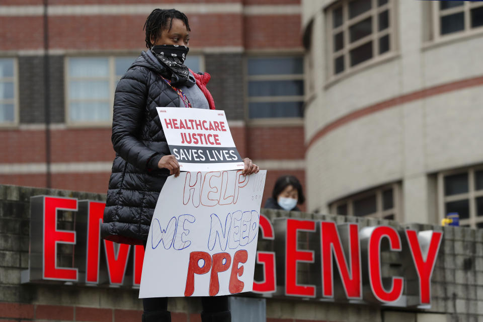 A nurse stands outside the emergency entrance to Jacobi Medical Center in the Bronx borough of New York, Saturday, March 28, 2020, as she demonstrates with members of the New York Nursing Association in support of obtaining an adequate supply of personal protective equipment for nurses coming in contact with coronavirus patients. A member of the New York nursing community died earlier in the week at another New York hospital. The city leads the nation in the number of coronavirus cases. Nurses say they are having to reuse their equipment endangering patients and themselves. (AP Photo/Kathy Willens)