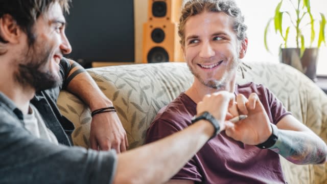 Young male friends smiling while smoking a marijuana joint