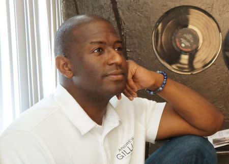 Candidate Andrew Gillum watches a video, which shows his rise from the son of a bus driver, to the mayor of Florida's capital city, who is seeking the Democratic nomination for state governor, during a campaign visit to a barbershop in Sarasota, Florida, U.S., July 18, 2018. REUTERS/Letitia Stein