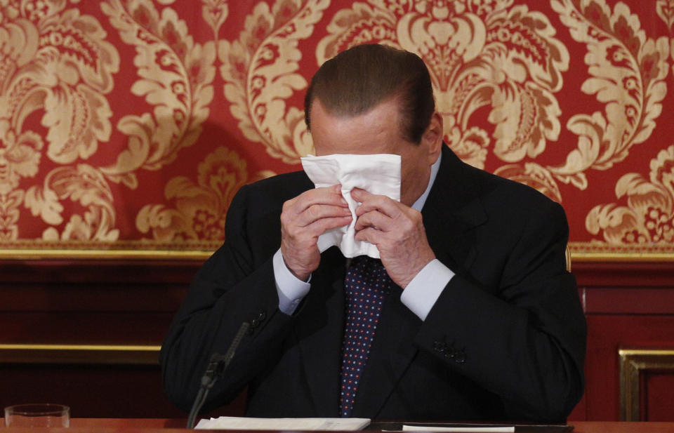 Former Italian Premier Silvio Berlusconi wipes his face during a press conference in Gerno, near Milan, Saturday, Oct. 27, 2012. Silvio Berlusconi, who announced this week he wouldn't run in spring elections, pulled an about-face Saturday and said he felt compelled to stay in politics to reform Italy's justice system after being convicted of tax fraud. (AP Photo/Luca Bruno)