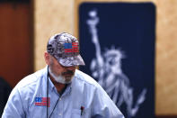 A participant wearing a Conservatives of States hat and shirt is seen in front of a Statue of Liberty sign before an Election Conspiracy Forum Saturday, March 11, 2023, in Franklin, Tenn. (AP Photo/Wade Payne)