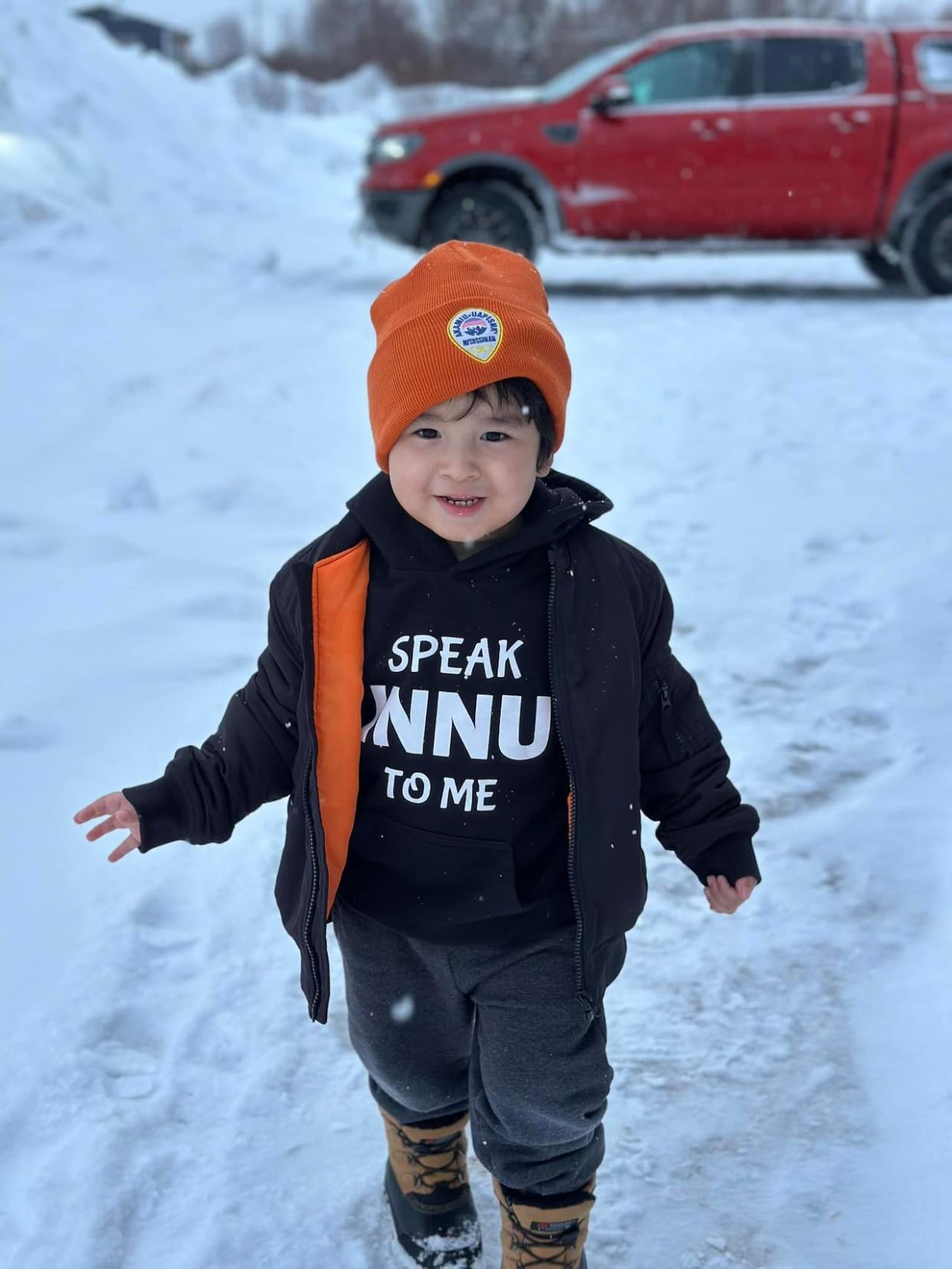 Megan Rich's son Daniel wears a sweater reading 'Speak Innu To Me.' Rich hopes the sweater encourages people to speak to him in Innu-aimun to help it become his first language.  (Megan Rich/Facebook - image credit)
