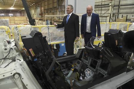 Managing Director Tony Birmingham (R) shows International Trade Secretary Liam Fox a Euro Fighter simulator, during a visit to EDM Ltd in Newton Heath, Manchester, Britain September 29, 2016. REUTERS/Anthony Devlin