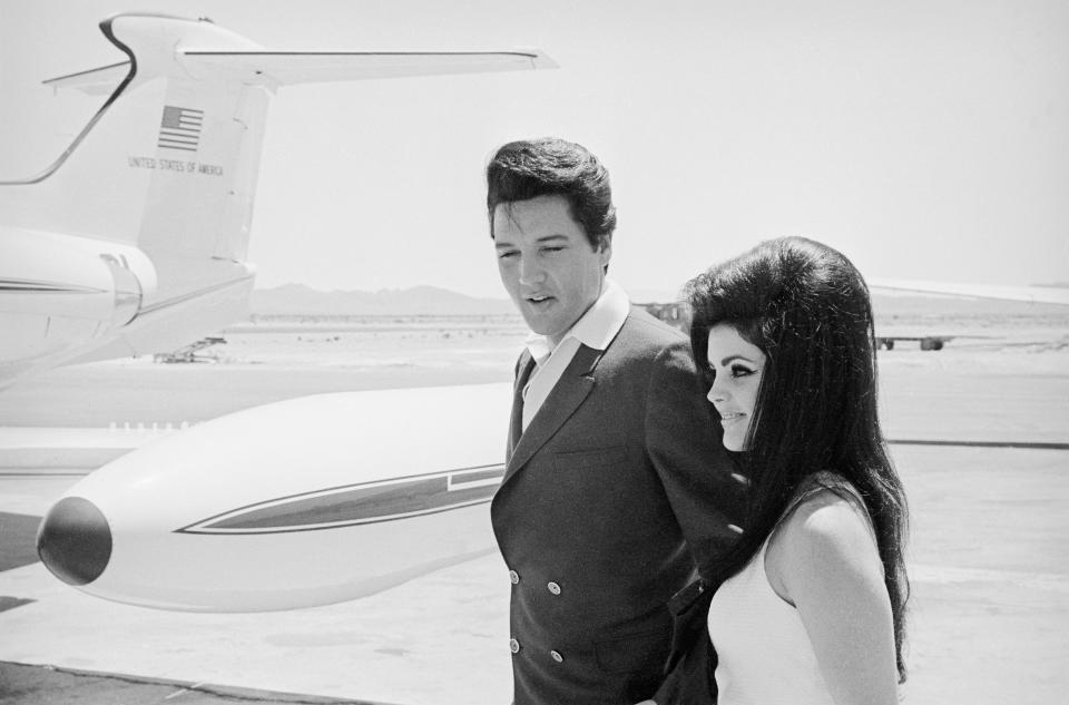 Singer Elvis Presley and his bride Priscilla Ann Beaulieu smile happily as they prepare to board a chartered jet airplane after their marriage at the Aladdin Hotel; January 01, 1967.