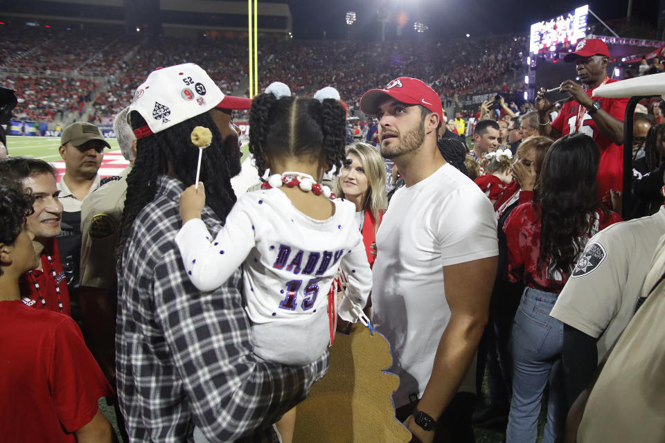 Las Vegas Raiders' Davante Adams, left, talks to Raiders quarterback Derek Carr as they wait for a halftime ceremony at which Adams' Fresno State jersey number was retired, at an NCAA college football game between Fresno State and San Jose State in Fresno, Calif., Saturday, Oct. 15, 2022. Carr also played at Fresno State. (AP Photo/Gary Kazanjian)