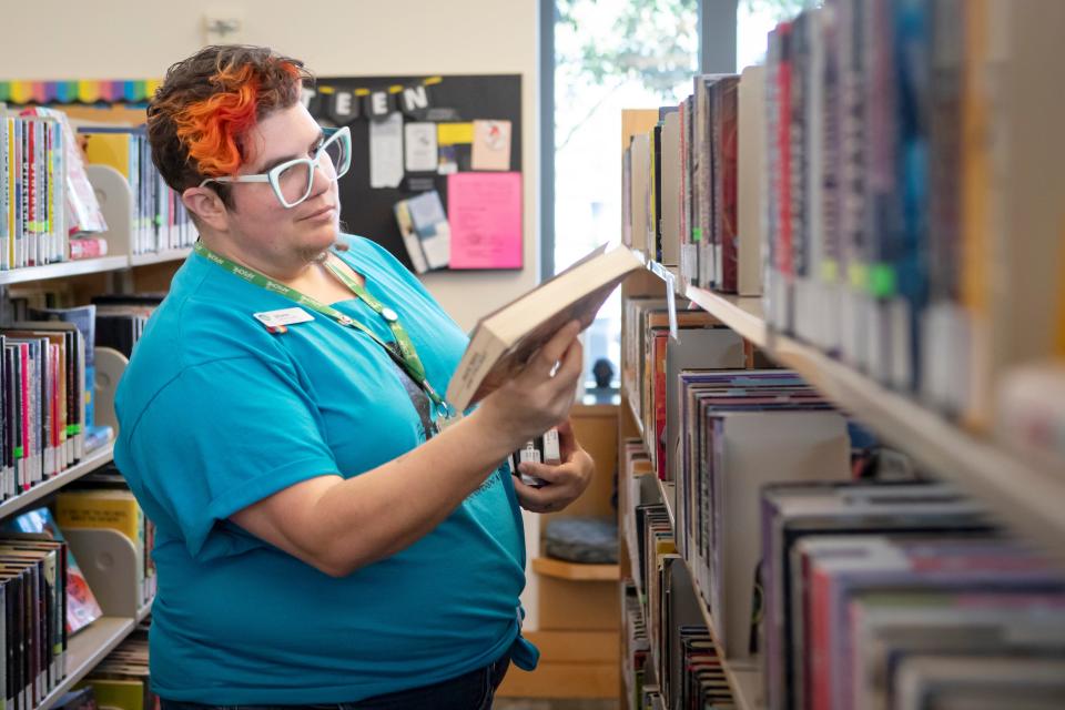 Staff member Jilynn Cherish stocks books in the teen section at the Eugene Public Library on Wednesday in preparation for the annuarl Support the Eugene Public Library book sale.