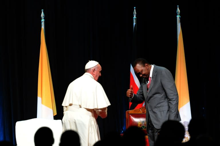 Kenyan President Uhuru Kenyatta (R) gives a thumbs up to Pope Francis at the State House of Nairobi on November 25, 2015