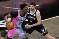 Brooklyn Nets' Joe Harris (12) defends against Miami Heat's Bam Adebayo (13) during the second half of an NBA basketball game Saturday, Jan. 23, 2021, in New York. (AP Photo/Frank Franklin II)