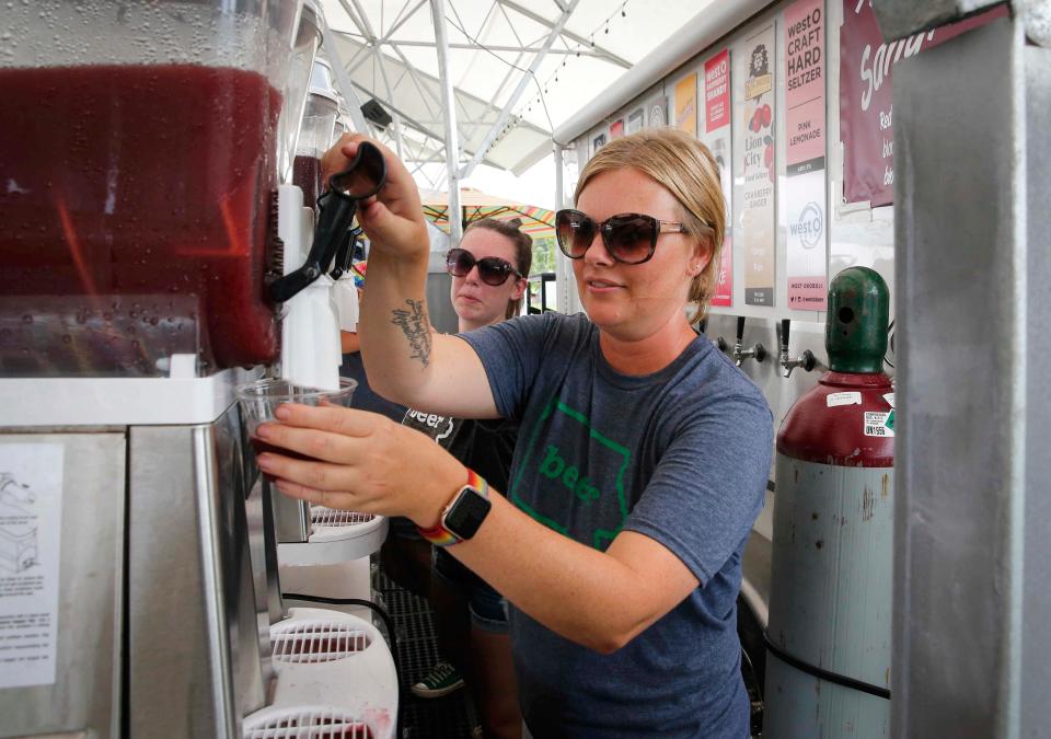 Monica Hudnut of Grinnell pours an Iowa-made seltzer at the Iowa Craft Beer Tent in 2021 during the opening day of the Iowa State Fair in Des Moines.