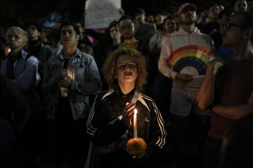 A demonstrator holds a candle during a protest in Mexico City, Monday, Nov. 13, 2023. The first openly nonbinary person to assume a judicial position in Mexico was found dead in their home Monday in the central Mexican city of Aguascalientes after receiving death threats because of their gender identity, authorities said. (AP Photo/Eduardo Verdugo)