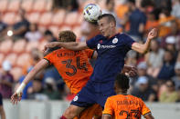 Chicago Fire's Boris Sekulić, right, heads the ball over Houston Dynamo's Thor Úlfarsson (34) during the first half of an MLS soccer game Saturday, June 25, 2022, in Houston. (AP Photo/David J. Phillip)