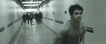 person running away from a group of people and sliding underneath a door