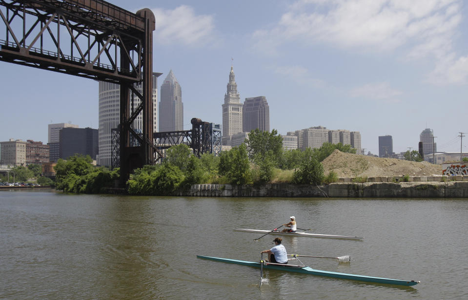 FILE – Two rowers paddle along the Cuyahoga River in Cleveland on July 12, 2011. Tuesday, Oct. 18, 2022, is the 50th anniversary of Congress passing the Clean Water Act to protect U.S. waterways from abuses like the oily industrial pollution that caused Ohio's Cuyahoga River to catch on fire in 1969. (AP Photo/Tony Dejak, File)