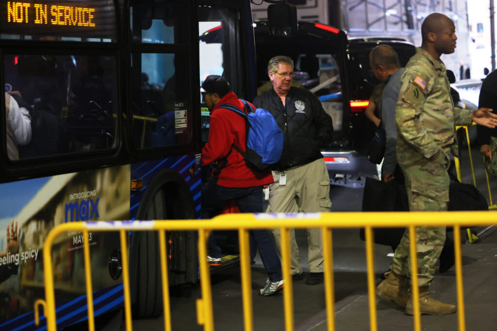 Asylum seekers board a bus