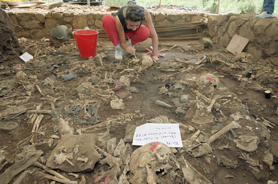 FILE - In this Oct. 23, 1992 file photo, forensic anthropologist Claudia Bernard, from Argentina, brushes dirt from human remains in El Mozote, El Salvador. Some 978 residents of the village of El Mozote, including 477 children, were killed in 1981 by soldiers who entered the area looking for guerrillas but who killed civilians instead, officials say. El Salvador's new President Nayib Bukele, who took office on June 1, 2019, promised to carry out the reparations ordered by an international court for relatives of the victims. (AP Photo/Michael Stravato, File)