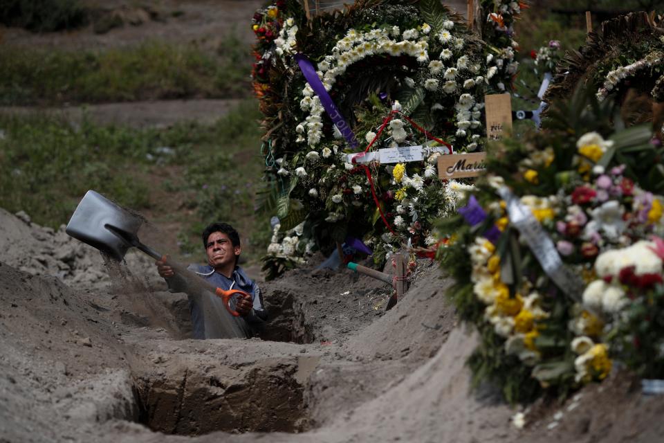 A cemetery worker digs a grave at the Valle de Chalco Municipal Cemetery on the outskirts of Mexico City on Sept. 24. The cemetery opened early in the coronavirus pandemic to accommodate the country's surge in deaths.