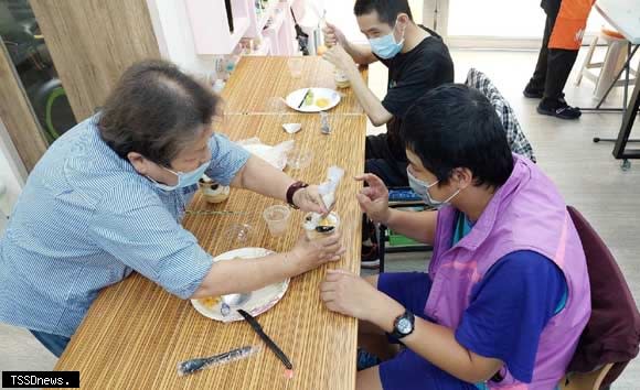 碧珠阿姨（圖左）與三峽國光日照中心服務對象阿翔共同DIY蛋糕。（圖：新北社會局提供）