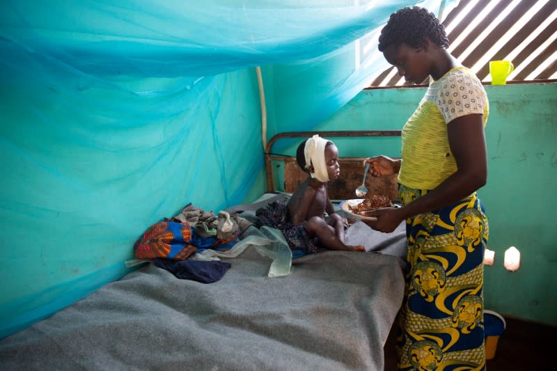 Allay Ngandema, who has developed complications after contracting measles, eats lunch with his mother Maboa Alpha in the measles isolation ward in Boso-manzi hospital in Mongala province