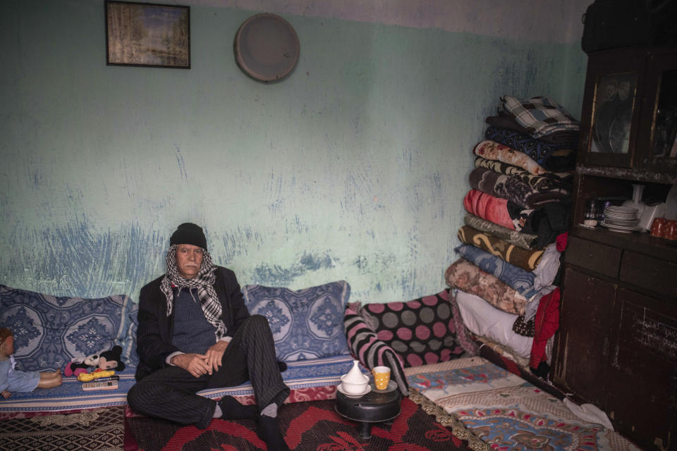 In this in Wednesday, March 25, 2020 photo, Ilias, 61, sit in his room in a housing complex in Sale, near Rabat, Morocco. Hundreds of people live in crowded rooms in this Moroccan housing complex with no running water and no income left because of the coronavirus lockdown measures. However volunteers come to help clean as the government tries to protect the population from virus while not punishing the poor. (AP Photo/Mosa'ab Elshamy)