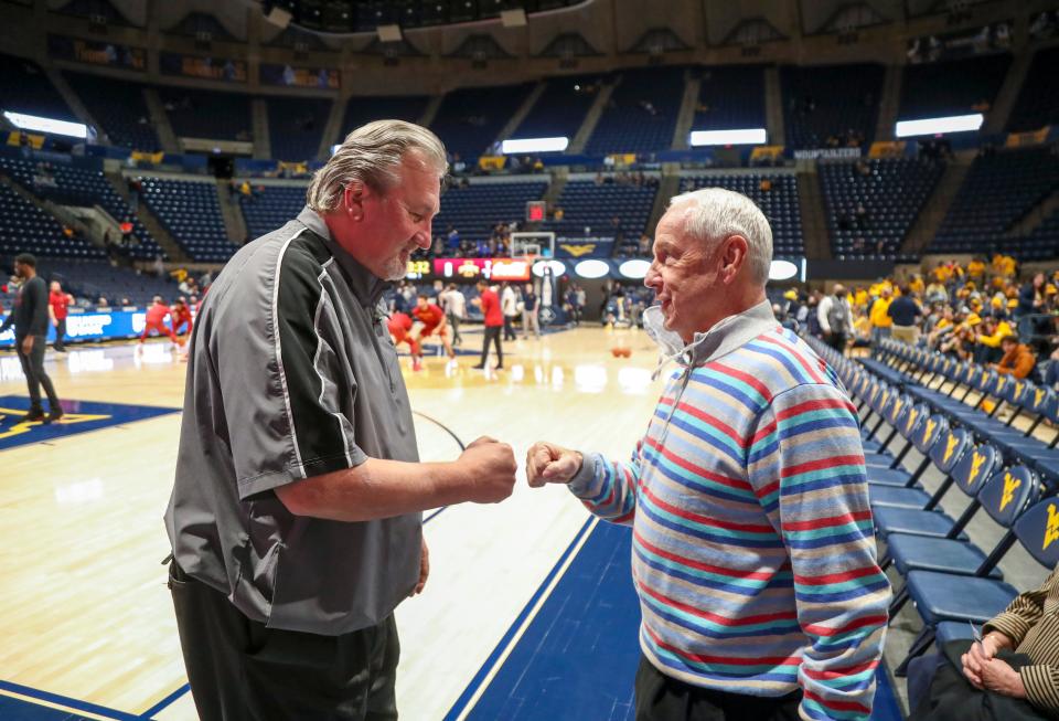 West Virginia head coach Bob Huggins (left) talks with former North Carolina head coach Roy Williams prior to the Mountaineers' game against Iowa State in February. Huggins will join Williams in the Basketball Hall of Fame later this year.