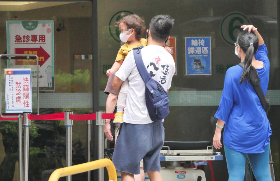 圖為3日醫院的防疫急門診外，一位家長抱著小孩前來看診。（陳俊吉攝）