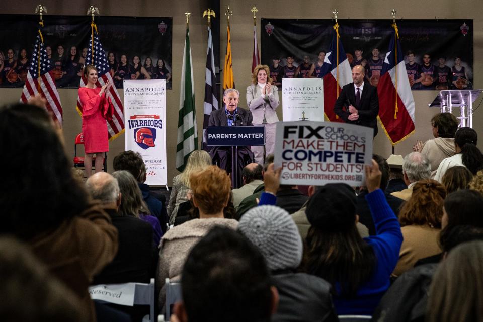 Texas Gov. Greg Abbott speaks during an event held by the Parent Empowerment Coalition at Annapolis Christian Academy on Tuesday, Jan. 31, 2023, in Corpus Christi, Texas. Nueces County Judge Connie Scott applauds on stage with the crowd. 
