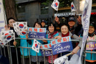 <p>Supporters hold South Korean flags and signs while waiting for a convoy transporting South Korean President Moon Jae-in to leave the Presidential Blue House for the inter-Korean summit, in Seoul, South Korea, April 27, 2018. (Photo: Jorge Silva/Reuters) </p>