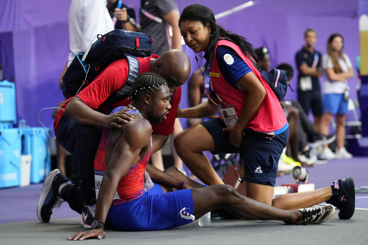 Noah Lyles is treated by medical staff 