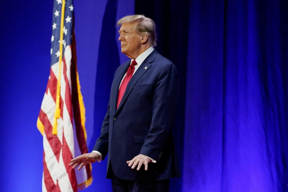 Trump stood still after entering the hall before eventually beginning to sway gently to the music (REUTERS)