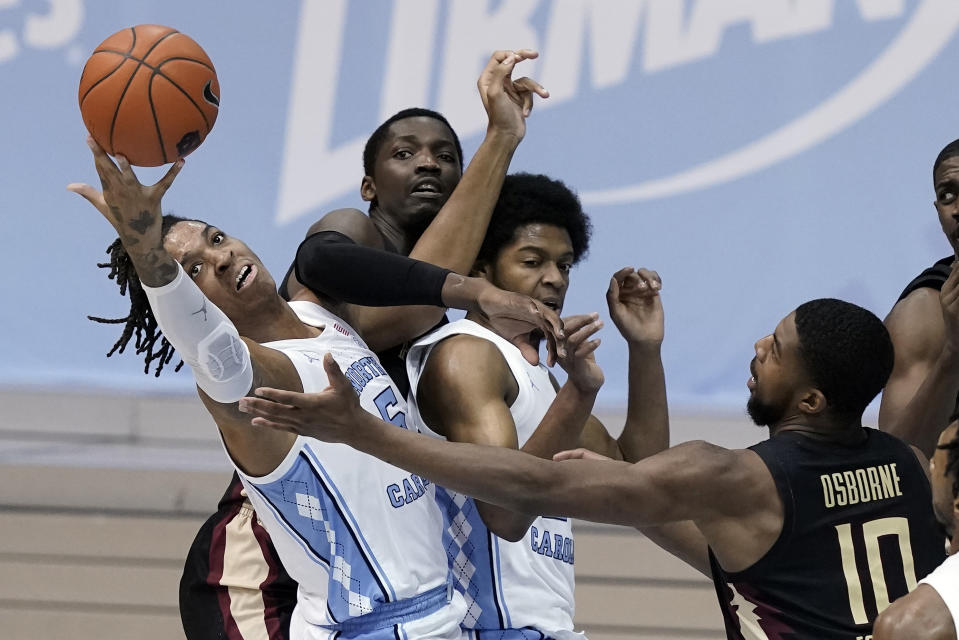 North Carolina forward Armando Bacot (5) and guard Kerwin Walton struggle with Florida State forward Malik Osborne (10) and center Tanor Ngom, rear, during the first half of an NCAA college basketball game in Chapel Hill, N.C., Saturday, Feb. 27, 2021. (AP Photo/Gerry Broome)