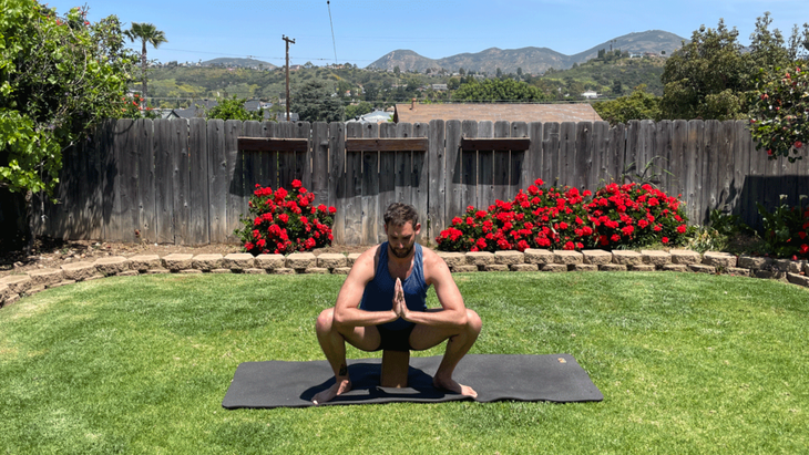 Man sitting on a yoga block 