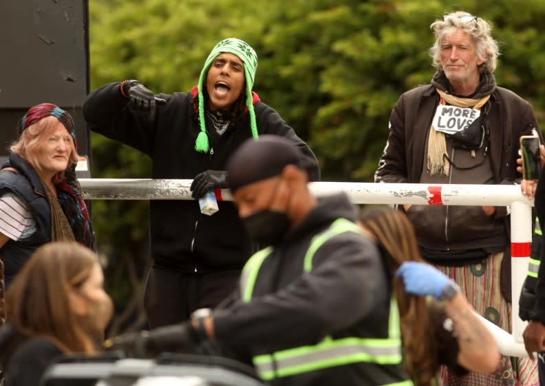 LOS ANGELES, CA - MARCH 25 - - Ayman Ahmed, 27, left, yells at police about homeless evictions from Echo Park in Los Angeles on March 25, 2021. Ahmed refused to leave and continued to stay inside Echo Park. Los Angeles official said they intend to close a homeless encampment at Echo Park and authorities ordered residents of the camp to clear out. There are many homeless who remain in Echo Park. (Genaro Molina / Los Angeles Times)